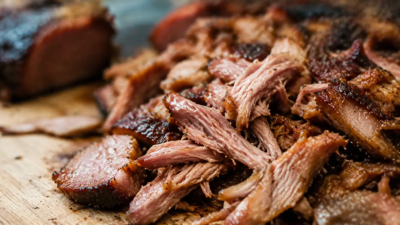 Close-up of shredded pork with visible bark strands, neatly pulled apart